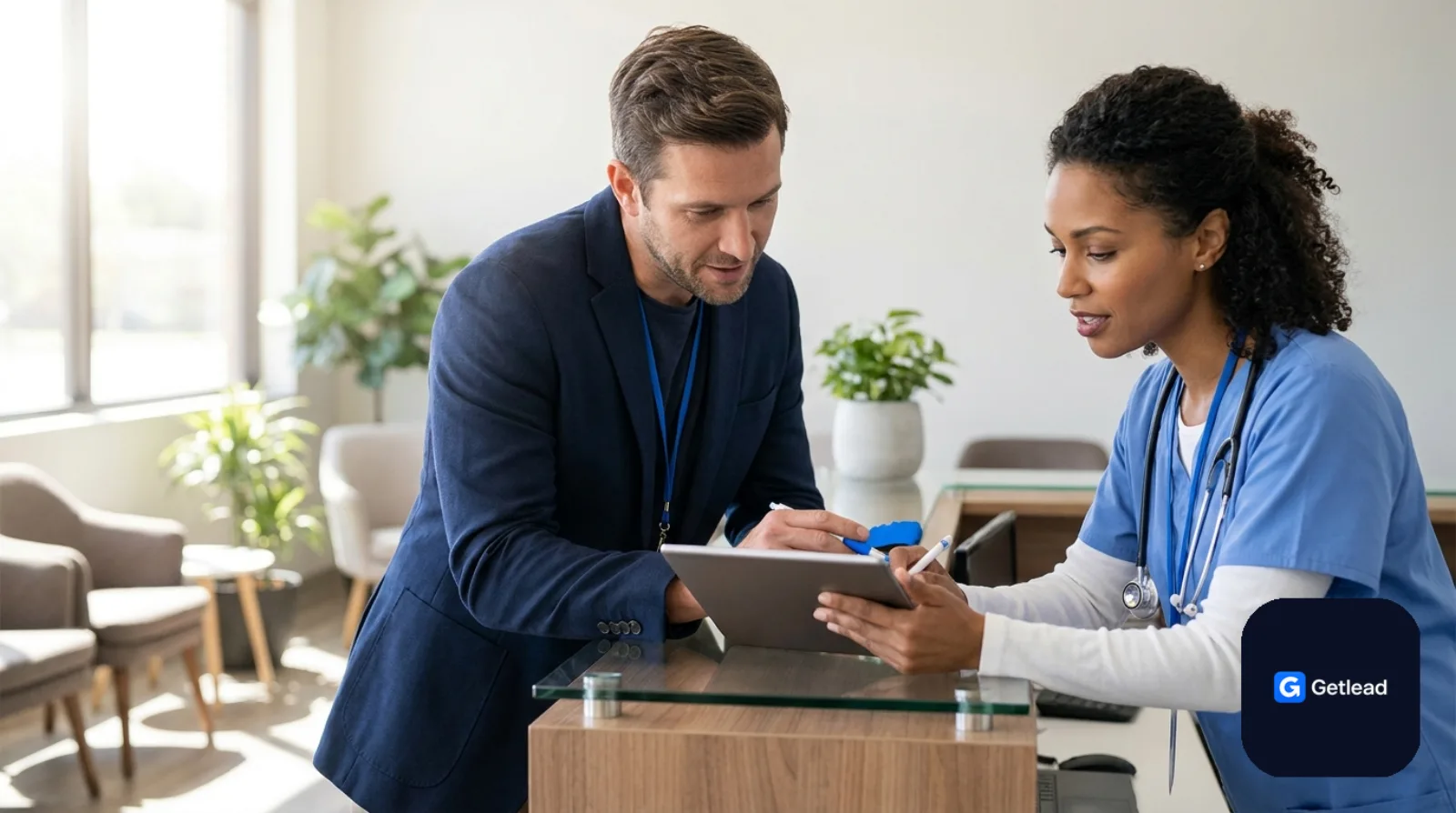 Practice manager and doctor reviewing a tablet at a clinic front desk